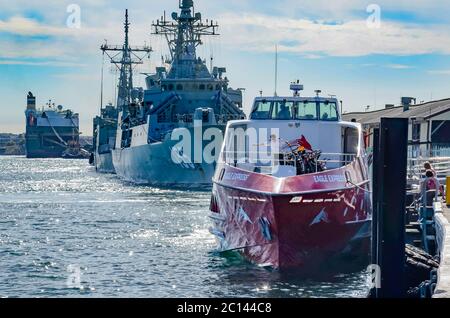 Vor der australischen Marine-Fregatte HMAS Ballarat vertäut, ist eine Rottnest Express-Fähre in Perth auf ihre nächste Reise nach Rottnest Island vorbereitet Stockfoto