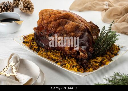 Gebratenes Schweineschulterschinken-Fleisch auf einer weißen Platte mit Geschirr Serviette und Kiefern Stockfoto