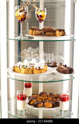 Kühlschrank mit verschiedenen Desserts auf den Regalen. Stockfoto