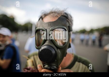 Artikeldetails mit einem Mann, der eine alte, alte, alte, militärische Gasmaske auf sein Gesicht legt. Stockfoto