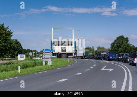 Schlange wartender Autos vor einer offenen Zugbrücke auf einer Autobahn in Lemmer, Niederlande. Ein Segelschiff kommt vorbei Stockfoto