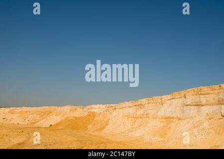 Klippe der gelb orange braun Sand Boden Ton unter den sonnigen Tag mit tiefblauen Himmel Stockfoto