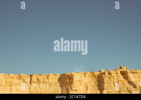 Klippe der gelb orange braun Sand Boden Ton unter den sonnigen Tag mit tiefblauen Himmel Stockfoto
