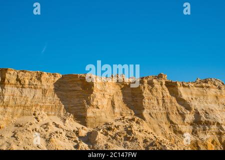 Klippe der gelb orange braun Sand Boden Ton unter den sonnigen Tag mit tiefblauen Himmel Stockfoto