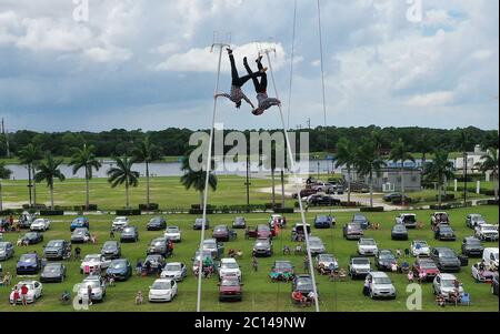 Sarasota, Usa. Juni 2020. (ANMERKUNG DER REDAKTION: Bild mit Drohne)Erendira Wallenda (links) und Alec Bryant treten auf den Swinkestangen bei der Daredevil Rally von Nik Wallenda auf, die als erste Drive-in-Stunt-Show der Welt im Nathan Benderson Park gilt. Die Show, die bis Juni 21 an ausgewählten Terminen stattfindet, zeigt international bekannte, waghalsige Darsteller und ist als sicheres Ereignis während der Coronavirus-Pandemie konzipiert, mit der Trennung der Zuschauer Fahrzeuge nach sozialen Distanzierungsrichtlinien. Kredit: SOPA Images Limited/Alamy Live Nachrichten Stockfoto