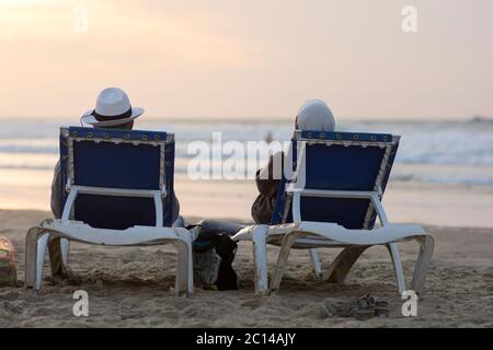 Mann und Frau sitzen und entspannen zusammen am Strand und beobachten den schönen Sonnenuntergang, Tel Aviv, Israel Stockfoto