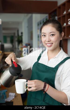 Junge hübsche Frau arbeitet im Café Stockfoto