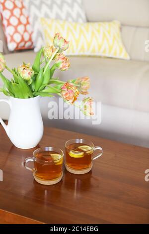 Schönes oranges Tulpenstrauß mit zwei Tassen Tee Stockfoto