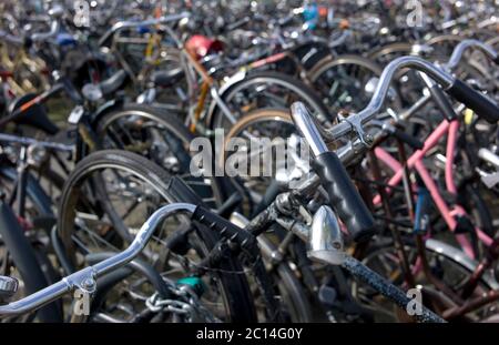 Parkplatz im Freien mit vielen farbigen Fahrrädern in Amsterdam, Niederlande. Stockfoto