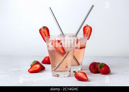 Eistee mit Erdbeeren und Eis auf weißem Hintergrund. Stockfoto