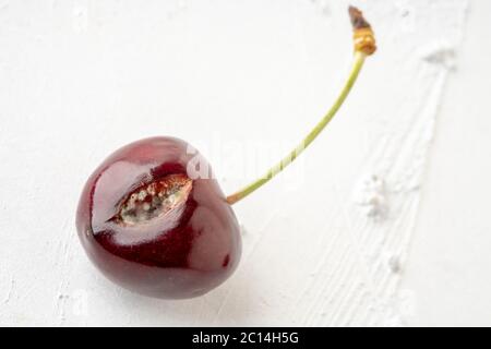 Nahaufnahme von schimmeligen Kirschfrüchten auf weißem Hintergrund mit Kopierraum Stockfoto