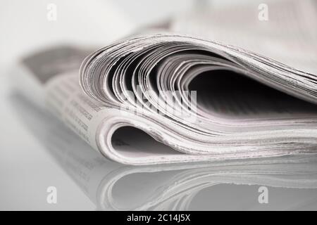 Zeitung auf Glastisch mit enger Schärfentiefe gespiegelt Stockfoto