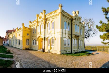 Bibliothek in Melnik mit wunderschönen Sonnenuntergängen. Historisches Gebäude mit einer gelben Mauer. Stadtbild der historischen Stadt Melnik 30 km nördlich von Prag, Stockfoto