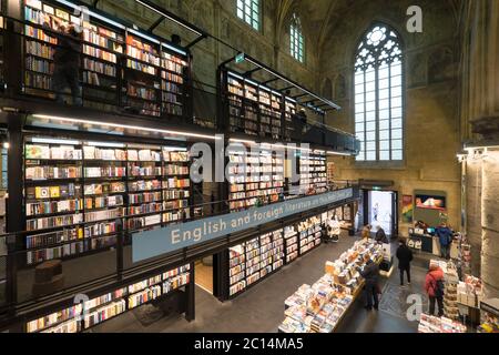 Innenansicht der Dominikanerkirche, die in eine Buchhandlung mit Restaurant, Kunden, Decken und Säulen der Kirche in Maastricht, Niederlande, umgewandelt wurde Stockfoto
