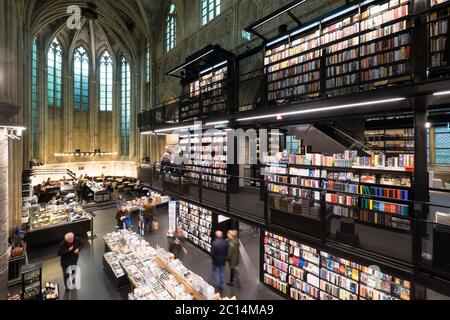 Innenansicht der Dominikanerkirche, die in eine Buchhandlung mit Restaurant, Kunden, Decken und Säulen der Kirche in Maastricht, Niederlande, umgewandelt wurde Stockfoto