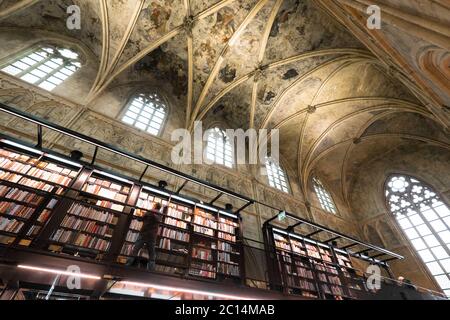 Innenansicht der Dominikanerkirche, die in eine Buchhandlung mit Restaurant, Kunden, Decken und Säulen der Kirche in Maastricht, Niederlande, umgewandelt wurde Stockfoto