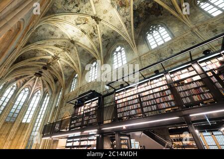 Innenansicht der Dominikanerkirche, die in eine Buchhandlung mit Restaurant, Kunden, Decken und Säulen der Kirche in Maastricht, Niederlande, umgewandelt wurde Stockfoto