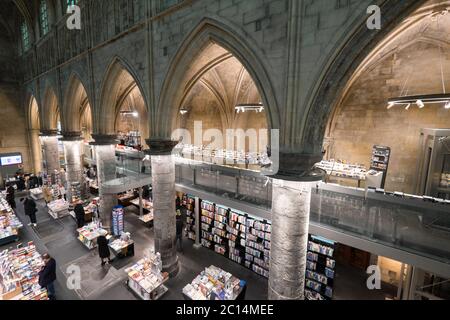 Innenansicht der Dominikanerkirche, die in eine Buchhandlung mit Restaurant, Kunden, Decken und Säulen der Kirche in Maastricht, Niederlande, umgewandelt wurde Stockfoto