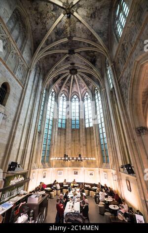 Innenansicht der Dominikanerkirche, die in eine Buchhandlung mit Restaurant, Kunden, Decken und Säulen der Kirche in Maastricht, Niederlande, umgewandelt wurde Stockfoto