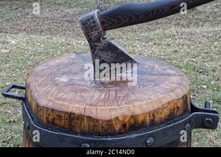 Die Axt klemmt im Schneidblock Stockfoto