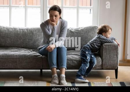 Unglückliche junge Mutter und kleiner Sohn ignorieren einander Stockfoto