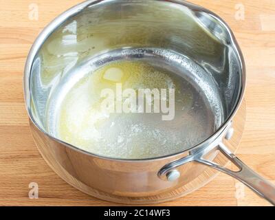 Butter wird in einer Pfanne geschmolzen. Gelbe Butter am Boden der Pfanne. Kochen. Stockfoto
