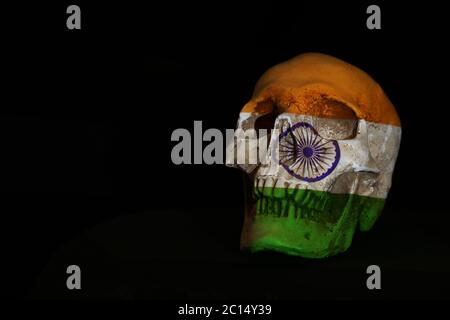 Indische Flagge Symbol Identität drapiert oder projiziert über einem isolierten Schädel vor einem schlichten schwarzen Hintergrund. Stockfoto