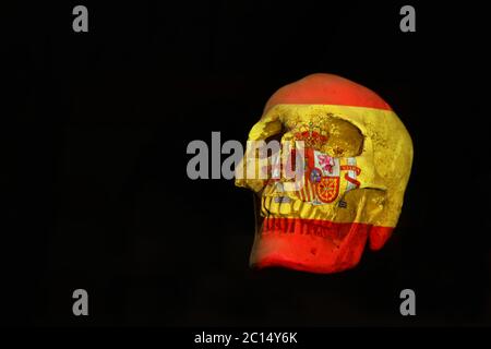 Isolierter weißer Schädel mit der spanischen Nationalflagge darüber. Schlichter schwarzer Hintergrund. Konflikt, Krankheit, Tod, beendet, Endkonzept Stockfoto