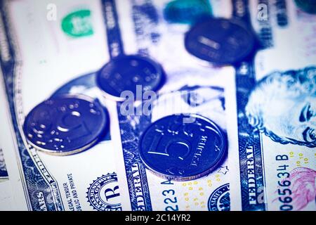 Rubel Münzen auf dem Hintergrund von Dollar-Scheinen. Wechselkurskonzept. Stockfoto