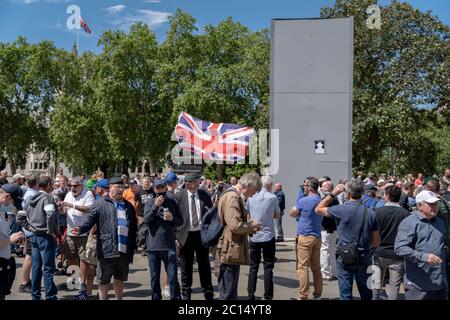 London, Großbritannien. Juni 2020. Nationalistische Anhänger versammeln sich um die geklammste Winston Churchill Statue auf dem Parliament Square. Tausende nationalistische, rechtsextreme und Fußballfans versammeln sich in Westminster, um gegen die kürzliche Entfernung und Verhüllung von Statuen und Gedenkstätten zu protestieren, insbesondere Winston Churchill auf dem Parliament Square. Polizei und Presse wurden häufig mit über 100 festgenommenen Personen angegriffen. Kredit: Guy Corbishley/Alamy Live Nachrichten Stockfoto