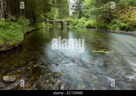 Ruhiger Fluss mit einer alten Brücke Stockfoto