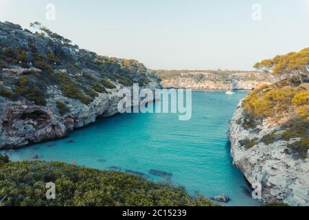 Panoramablick auf den Sonnenuntergang von Es calo des Moro schöner Strand. Schatten von Kiefern auf kristallklarem Wasser. Klassifiziert als einer der besten Strände der Welt. Stockfoto