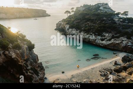 Panoramablick auf den Sonnenuntergang von Es calo des Moro schöner Strand. Schatten von Kiefern auf kristallklarem Wasser. Klassifiziert als einer der besten Strände der Welt. Stockfoto