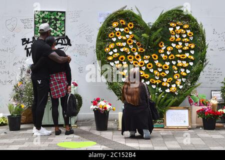 Menschen in der Grenfell Memorial Community Mosaik am Fuße des Tower Blocks in London zum dritten Jahrestag des Grenfell Tower Feuers, der am 14 2017. Juni 72 Menschenleben forderte. Stockfoto