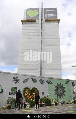 Menschen in der Grenfell Memorial Community Mosaik am Fuße des Tower Blocks in London zum dritten Jahrestag des Grenfell Tower Feuers, der am 14 2017. Juni 72 Menschenleben forderte. Stockfoto