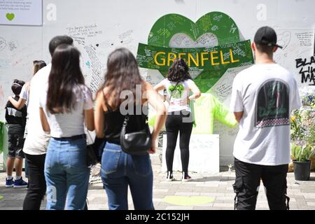 Menschen in der Grenfell Memorial Community Mosaik am Fuße des Tower Blocks in London zum dritten Jahrestag des Grenfell Tower Feuers, der am 14 2017. Juni 72 Menschenleben forderte. Stockfoto