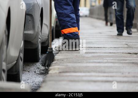 Prozess der städtischen Straßenreinigung fegen. Arbeiter mit Besen und Staubwanne Stockfoto