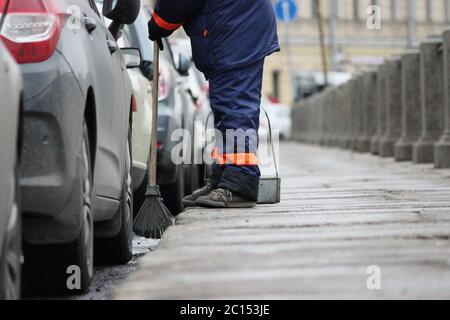 Prozess der städtischen Straßenreinigung fegen. Arbeiter mit Besen und Staubwanne Stockfoto