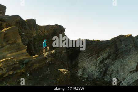 Wanderer steht an der scharfen Ecke und genießt die schöne Aussicht bei Sonnenuntergang. Leerzeichen für Text. Urlaubskonzept Stockfoto
