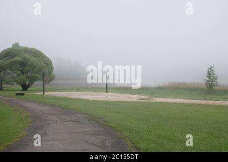Mystisches Nebelbild an einem leeren Strand früh am Morgen, verschwommener nebliger Seegrundgrund Stockfoto