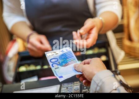 Die Frau zahlt in bar mit Euro-Banknoten Stockfoto