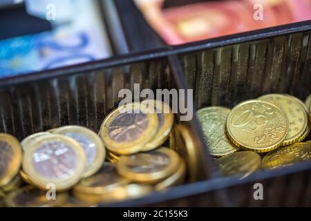 Offener Registrierkassen mit vielen Münzen von Euro und Banknoten Stockfoto