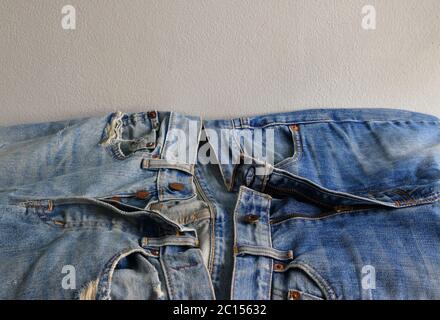 Nahaufnahme und selektiver Fokus von Button Fly Jeans und Zipper Fly Jeans im Vergleich Stockfoto