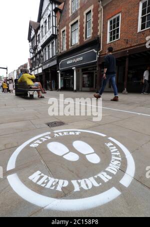 Die Menschen gehen an einem sozialen Distanzierungsschild in der High Street in Winchester vorbei, bevor am 15. Juni die nicht unbedingt notwendigen Einzelhändler in England wieder eröffnet werden. Stockfoto