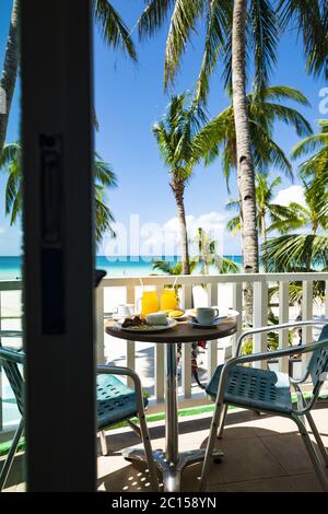 (Selektiver Fokus) EIN Frühstück, bestehend aus Orangensaft, Obst, Kaffee, Reis, Fleisch und Eiern, wird auf einem Balkon mit atemberaubender Aussicht serviert. Stockfoto