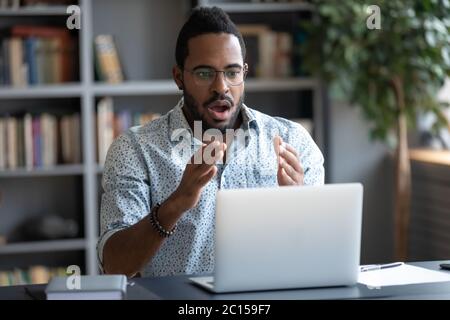 African Kerl fühlt sich schockiert Blick mit Erstaunen auf Laptop-Bildschirm Stockfoto