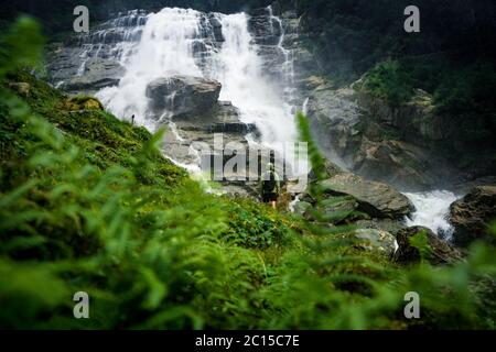 Fotograf mit Rucksack genießen erstaunliche Wasserfall Reise Lifestyle und Erfolgskonzept Urlaub in der wilden Natur. Grawa Wasserfall in Stubaita Stockfoto