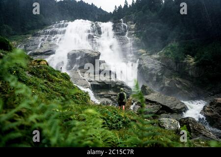 Fotograf mit Rucksack genießen erstaunliche Wasserfall Reise Lifestyle und Erfolgskonzept Urlaub in der wilden Natur. Grawa Wasserfall in Stubaita Stockfoto