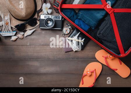 Bereiten Sie Zubehör und Reiseartikel mit Gepäck auf Holzbrett, flach legen, Draufsicht Hintergrund Sommer Konzept Stockfoto