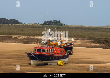 Zwei Rettungsboote sitzen auf den Schlammlappen und warten darauf, auf der Flut wieder aufzuschwimmen. Stockfoto